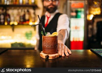 Barkeeper shows attractive alcoholic cocktail. Handsome alcohol beverage preparation