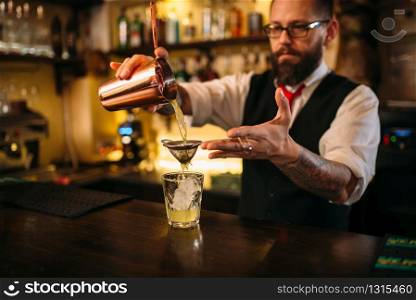 Barman flaring behind bar counter. Restaurant shelves with alcoholic drinks bottles on background