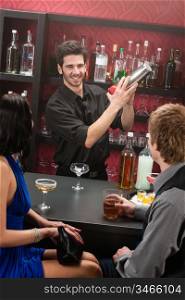 Barman making cocktail for young couple at the bar