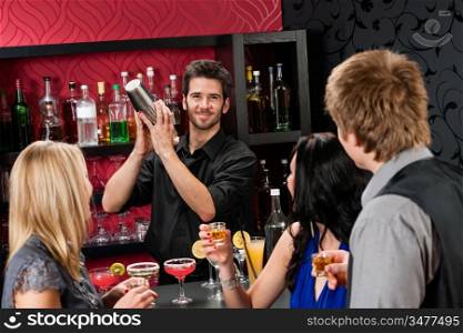 Barman making cocktail for young friends at the bar