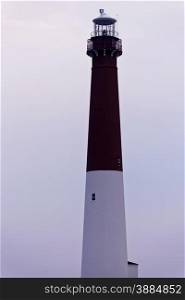 Barnegat Lighthouse, part of State Park at Barnegat Light on the northern tip of Long Beach Island in Ocean County, New Jersey, USA. Pastel colors in the sky of vertical image with copy space.