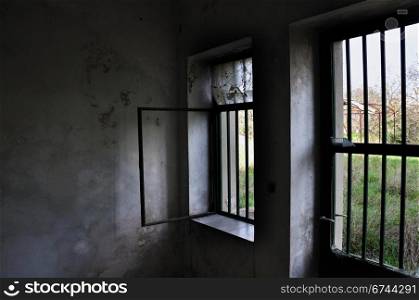 Barred door and windows in abandoned house interior.