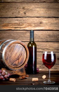 Barrel, a bottle and a glass of red wine. On a wooden background. . Barrel, a bottle and a glass of red wine.