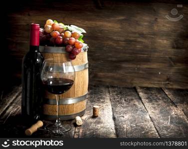 barrel of red wine with grapes and a corkscrew. On a wooden background.. barrel of red wine with grapes and a corkscrew.