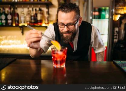 Bartender behind bar counter making alcohol coctail in restaurant. Bartender making alcohol coctail in restaurant