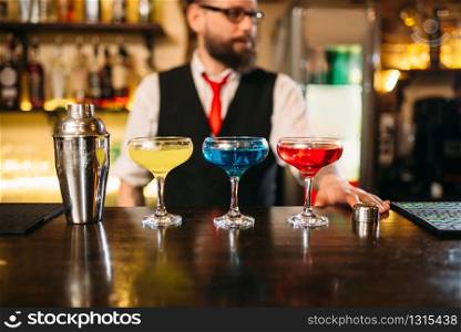 Bartender behind bar counter show alcohol coctails in restaurant. Bartender behind bar counter show alcohol coctails