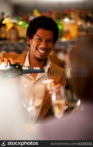 Bartender pouring champagne at bar