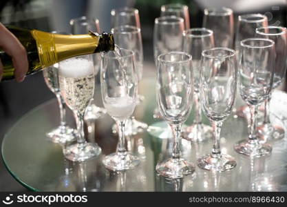 bartender pours ch&agne into a glass