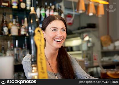 Bartender serving drinks in pub, London