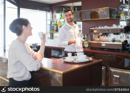 bartender with customer holding a cup of coffee