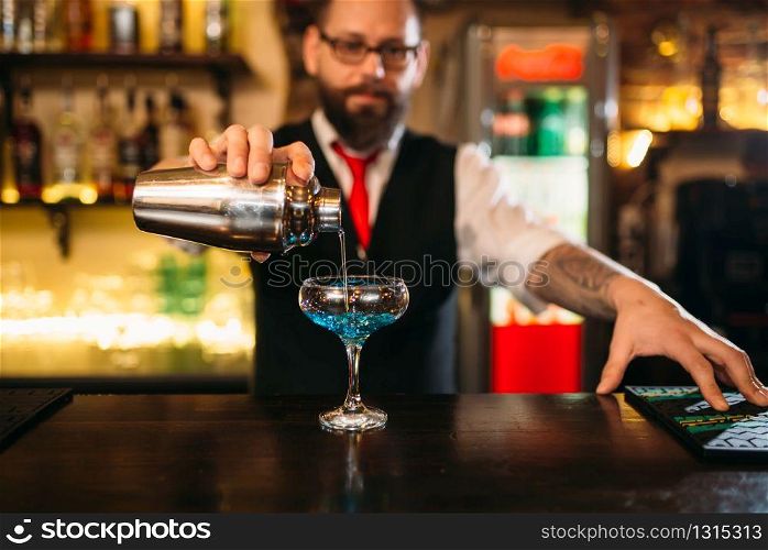 Bartender with shaker making alcohol cocktail behind a bar counter. Bartender with shaker making alcohol cocktail