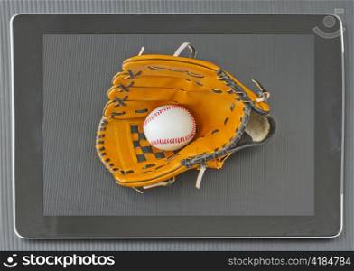 Baseball glove with a ball in the screen of a tablet