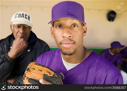Baseball Player Standing in Dugout with Coach