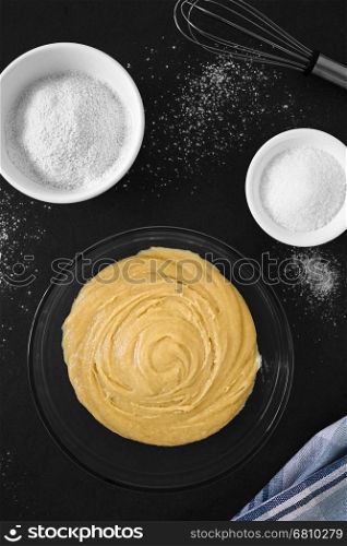 Basic homemade cake or cookie dough in glass bowl with ingredients on the side, photographed overhead on slate with natural light