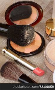Basic make-up products close up - foundation, powder and lipstick