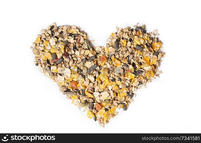 basic muesli  with fruits for horse background  in form of heart. isolated