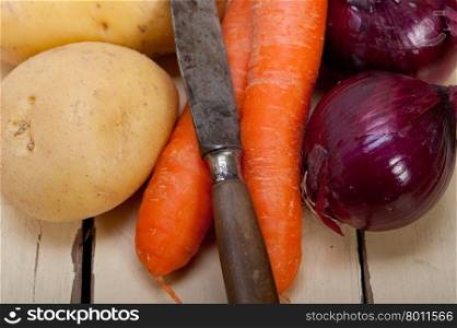 basic vegetable ingredients carrot potato onion on a rustic wood table&#xA;