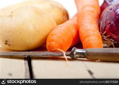 basic vegetable ingredients carrot potato onion on a rustic wood table&#xA;