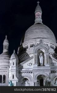 Basilica Sacre Coeur in Montmartre at night. Portrait format with copy space in sky at top left.