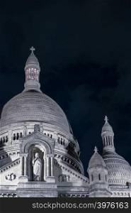Basilica Sacre Coeur in Montmartre at night. Portrait format with copy space in sky at top right.