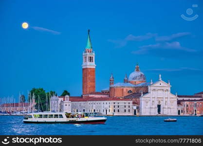 Basilica San Giorgio Maggiore Church with vaporetto waterbus seen across the Venice lagoon with full moon. Venice, Italy. San Giorgio Maggiore Church with full moon. Venice, Italy
