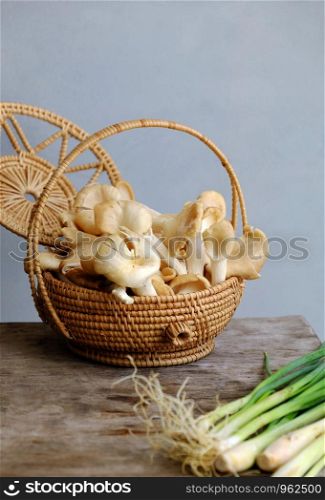 Basket abalone mushroom and citronella plant on wooden background, this vegetables is popular ingredient for Vietnamese vegan food