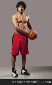 Basket ball player standing over grey background