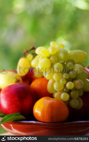 basket full of fresh fruits, pears, peaches, tangerine and grapes