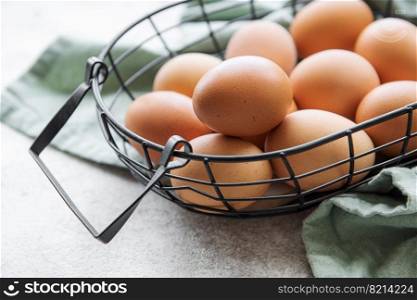 Basket of fresh brown eggs on concrete background