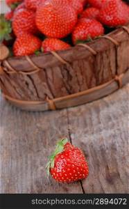 Basket of fresh strawberries on wooden board