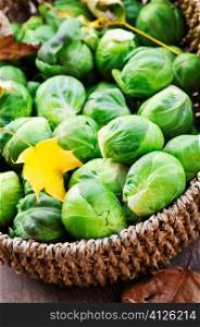 Basket of green brussels sprouts with autumn leaves