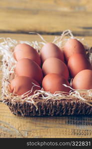 Basket of raw chicken eggs on the wooden background