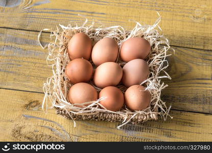 Basket of raw chicken eggs on the wooden background