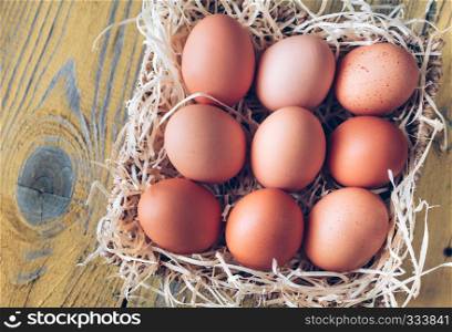 Basket of raw chicken eggs on the wooden background
