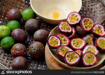 Basket passion fruits and passiflora edulis cut in half, kind of seedy fruit or with soft pulp and seeds inside hard rind