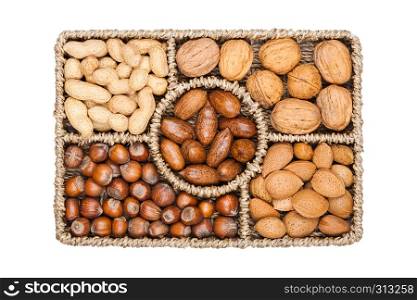 Basket reach in various kinds of nuts in shells, pecans, almonds, hazelnuts, peanuts and walnuts on white background