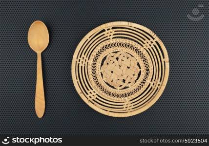 Basket wicker is handmade and wooden spoon on a dark background