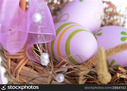 basket wicker with decoration easter eggs on hay