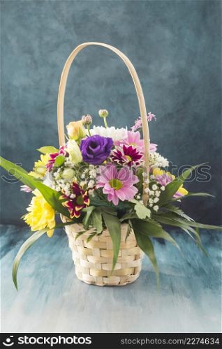 basket with different flowers placed desk