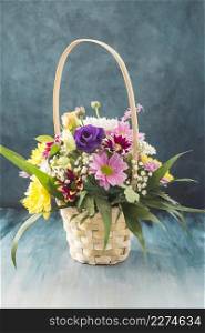 basket with different flowers placed desk