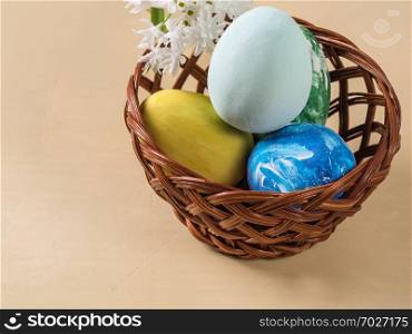 Basket with dyed Easter eggs on a light background