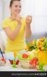 Basket with Easter eggs and painting on egg woman in background