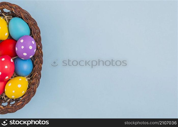basket with easter eggs blue table