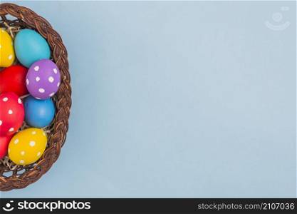 basket with easter eggs blue table
