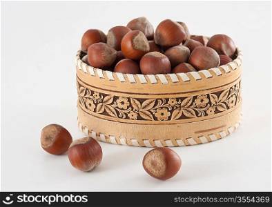 basket with hazelnuts on white background