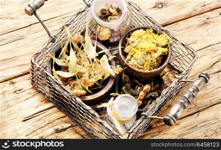 Basket with medicinal herbs. Desiccated herbs and plants in metal basket on a wooden background.Herbs medicine.Natural herbs medicine