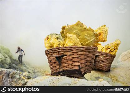 Basket with sulfur inside crater of Ijen volcano, East Java, Indonesia