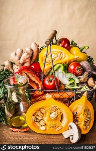 Basket with various autumn seasonal organic harvest vegetables and pumpkin at wall background, front view. Autumn food inspiration