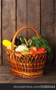Basket with vegetables and fresh herbs on the wood background with copy space