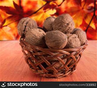 Basket with walnuts with a blurred background. Basket with walnuts. The background of their red and yellow leaves blurred.